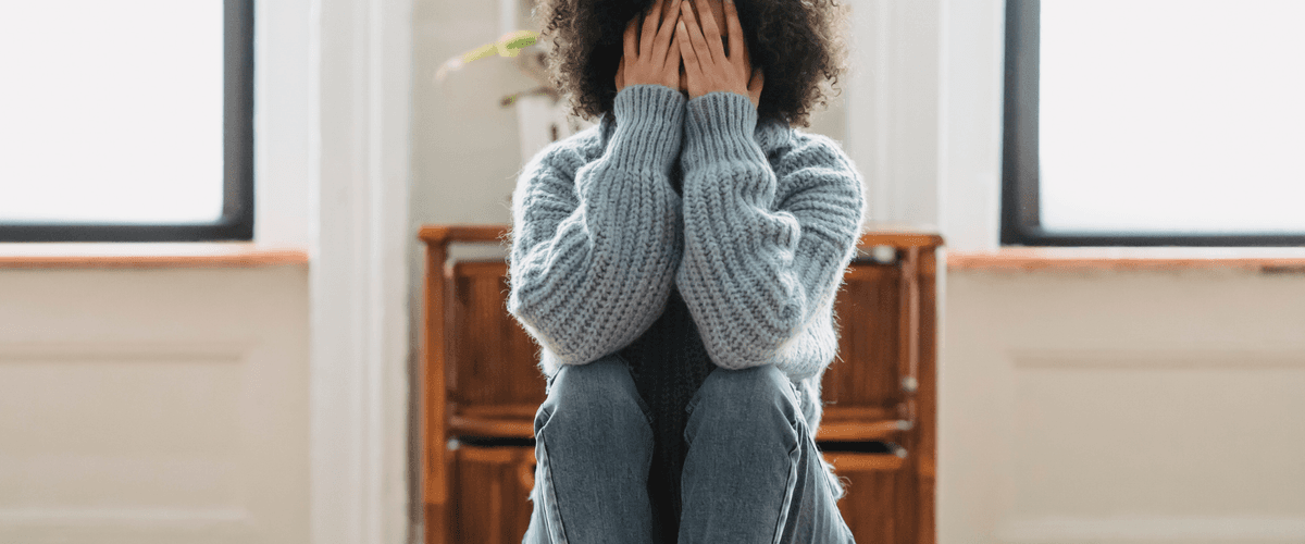 Woman covering her face with her hands