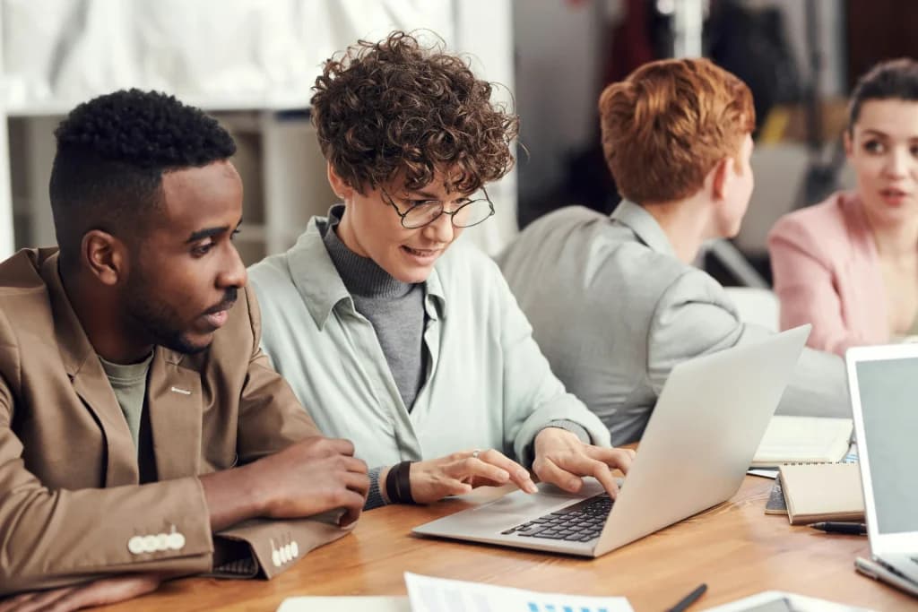 Colleagues working together on laptops at a shared desk