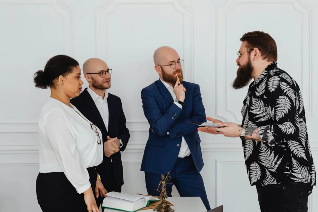 Four colleagues standing in discussion in an office